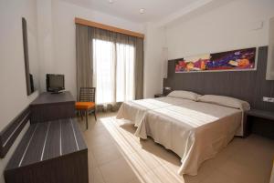 a bedroom with a bed and a television in it at Alcocebre Suites Hotel in Alcossebre