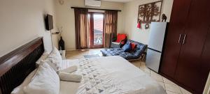 a living room with a bed and a refrigerator at Ocean View Villas F10 in Port Edward