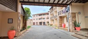 an empty alleyway between two buildings with plants at Ocean View Villas F10 in Port Edward