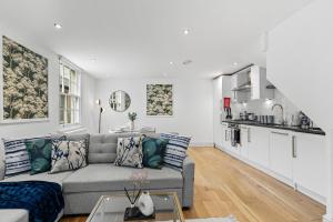 a living room with a couch and a kitchen at Stylish Roman Bath Abode - The Gatsby in Bath