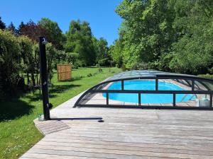 a glass pavilion with a pool in a park at L'atypique du buisson de la gariole in Aubigny-sur-Nère