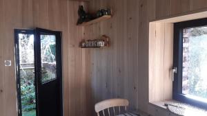 a room with a wooden wall with a door and a chair at L'atypique du buisson de la gariole in Aubigny-sur-Nère