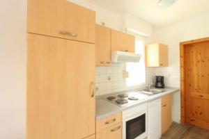 a kitchen with wooden cabinets and a stove top oven at Bungalow Marina Tarnewitz in Tarnewitz