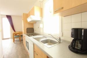a kitchen with a sink and a microwave at Bungalow Marina Tarnewitz in Tarnewitz +7 photos