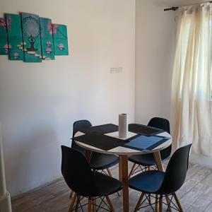 a table and chairs in a room with a painting at Terramar cabañas in Mar del Plata