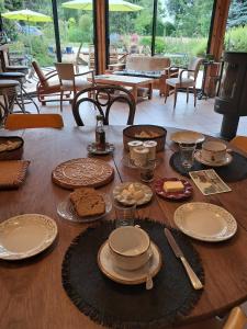 a wooden table with plates and food on it at L'atypique du buisson de la gariole in Aubigny-sur-Nère