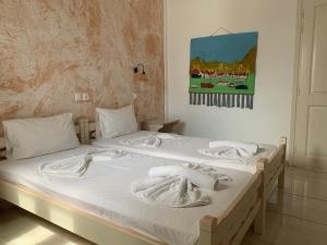 two beds in a bedroom with towels on them at Melissa Chora in Koufonisia