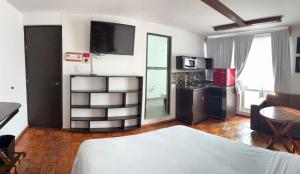a living room with a bed and a kitchen with at Suites Aldama in Toluca