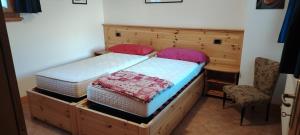 a bedroom with a large bed with a wooden headboard at La Dimora della Quiete in Valdidentro