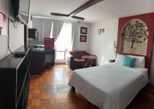a hotel room with a bed and a television at Suites Aldama in Toluca