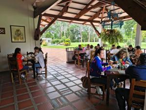 a group of people sitting at tables in a restaurant at Hotel Pueblito Cafetero in Pereira