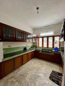 an empty kitchen with wooden cabinets and green counter tops at Dragster Homes Alwaye in Alwaye