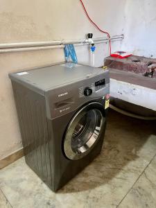 a washing machine sitting in the corner of a room at Dragster Homes Alwaye in Alwaye