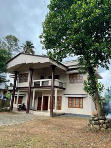 a building with a tree in front of it at Dragster Homes Alwaye in Alwaye