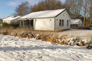 a white house in the snow next to a field at Vakantiewoning Hemme Limburg in Simpelveld