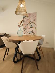 a dining room table with chairs and a vase with flowers at Vakantiewoning Hemme Limburg in Simpelveld
