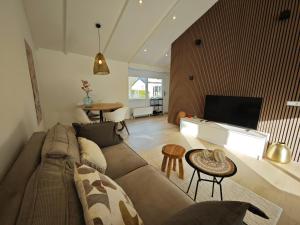 a living room with a couch and a tv at Vakantiewoning Hemme Limburg in Simpelveld