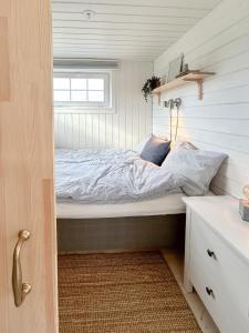 a bed in a small room with a window at Minihus i lantlig miljö nära havet in Smygehamn