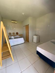 a bedroom with a bed and a refrigerator in it at Pousada Barlavento in Luis Correia