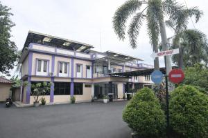 a house with a palm tree in front of it at Mekarsari Hotel By ARBA in Tjipitjung Tiga