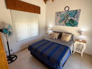 a bedroom with a bed and a fan and a window at Duplex 4 con cochera privada y parrilla in San Clemente del Tuyú