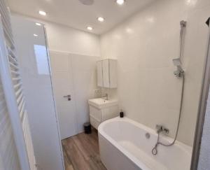a white bathroom with a tub and a toilet at Süße Marie 10 in Karlsruhe