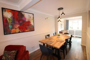 a dining room with a wooden table and chairs at Spacious 5 Bedroom House Addlestone in Addlestone