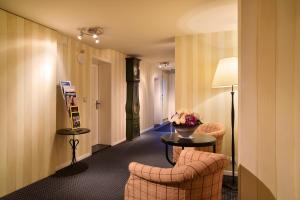 a hotel room with two chairs and a table with flowers at Romantik Hotel Schwan in Horgen