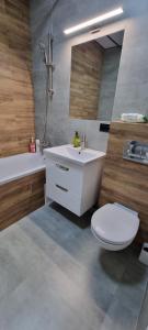 a bathroom with a sink and a toilet and a tub at Панорама Апарт готель in Ternopil
