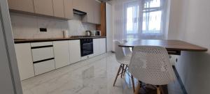 a kitchen with a wooden table and white cabinets at Панорама Апарт готель in Ternopil