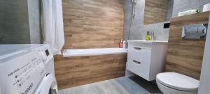 a bathroom with a toilet and a tub and a sink at Панорама Апарт готель in Ternopil