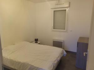 a small bedroom with a bed and a window at Maison individuelle neuve plein pied avec terrasse et jardin clos 15 minutes a pied de la plage arrivé a partir de 15h30 in Quiberville