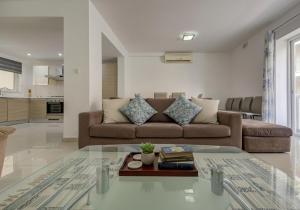 a living room with a couch and a table at Central, spacious apartment with Sea Views in St. Paul's Bay