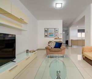 a living room with two couches and a glass table at Central, spacious apartment with Sea Views in St. Paul's Bay