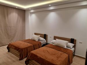 two beds in a room with a wall at New Cairo Cozy Studio استديو فندقى بالتجمع in New cairo