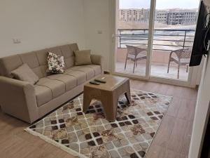 a living room with a couch and a table at New Cairo Cozy Studio استديو فندقى بالتجمع in New cairo