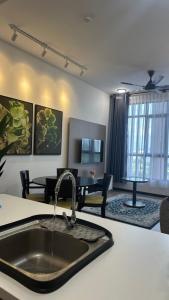 a kitchen with a sink and a living room at Putrajaya Antara Residence, Near PICC, Presint 5 in Putrajaya