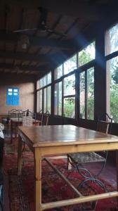 a large wooden table in a room with windows at Ecolodge du Draa in Ouled Otmane