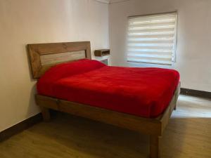 a bedroom with a red bed in a room with a window at Selva Hospedaje in Valparaíso