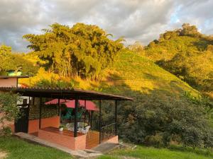 a small building with a hill in the background at Posada El Remolino in Anolaima +18 photos