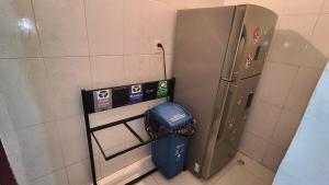a bathroom with a trash can and a refrigerator at San House TEN in Zipaquirá
