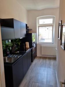 a kitchen with black counters and a sink and a window at Süße Marie 11 in Karlsruhe
