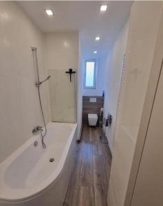 a white bathroom with a tub and a toilet at Süße Marie 11 in Karlsruhe