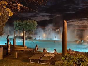 a group of people in a swimming pool at night at Casa Caleidos - Sirmione4u in Sirmione