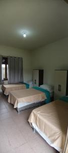 a bedroom with three beds in a room at Espaço Casa Cult in Serra