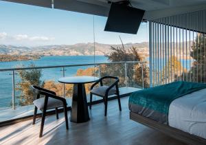a bedroom with a bed and a table and a large window at Entre Islas LODGE in Aquitania