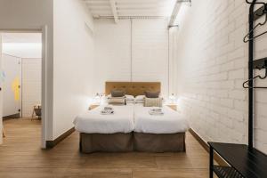 a bedroom with a large bed with white walls at Nut Hostel in Granada