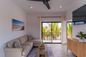 a living room with a couch and a tv at Modern House, Rooftop Ocean Views & Private Pool in El Centenario