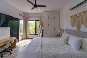 a bedroom with a bed and a desk and a window at Modern House, Rooftop Ocean Views & Private Pool in El Centenario