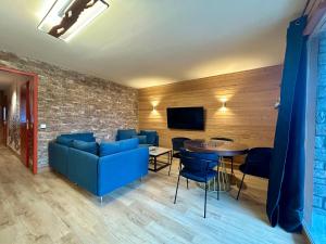 a living room with a blue couch and a table at Alpine Mood - Vue - Balcon - Parking in Uvernet